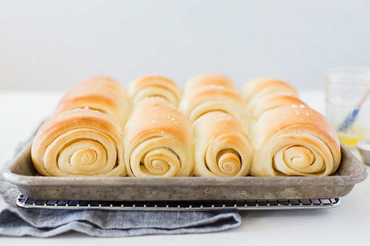 Utah's Famouse Lion House Rolls on a baking sheet set on a cooling rack.