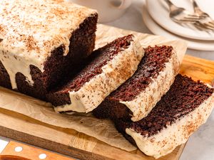 Chocolate stout loaf cake on a wooden board, with a few slices cut