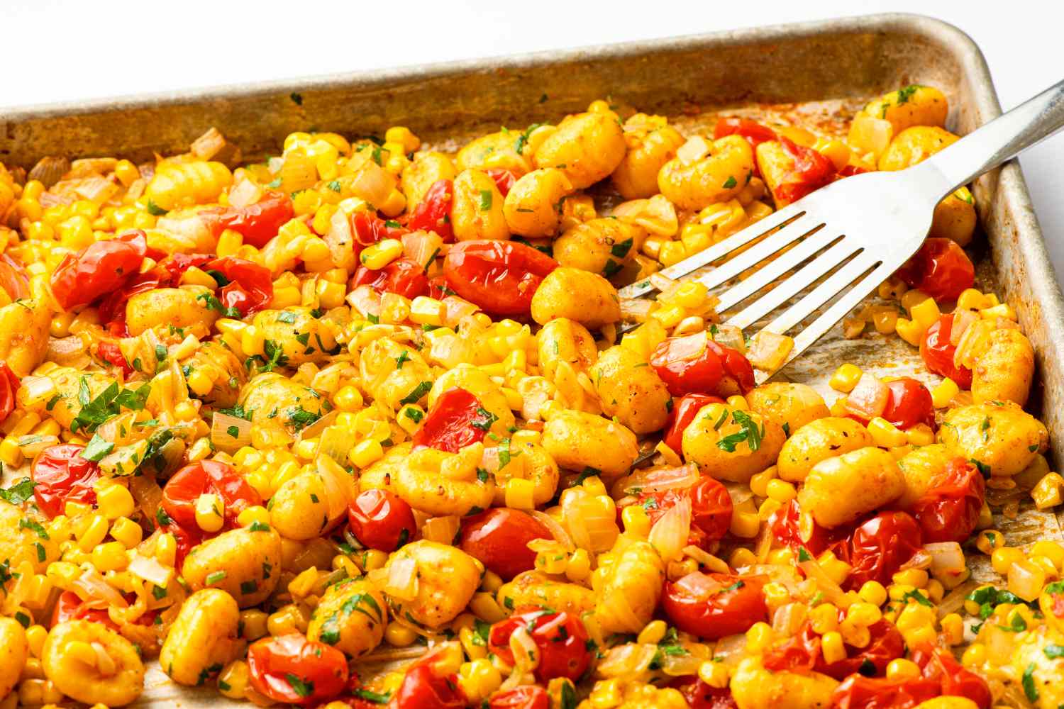 Sheet pan with roasted gnocchi, cherry tomatoes, and diced vegetables