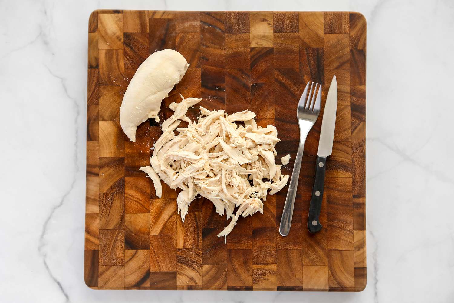 Shred chicken on a cutting board
