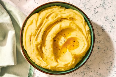 Golden mashed potatoes with a melting pat of butter and black pepper on top