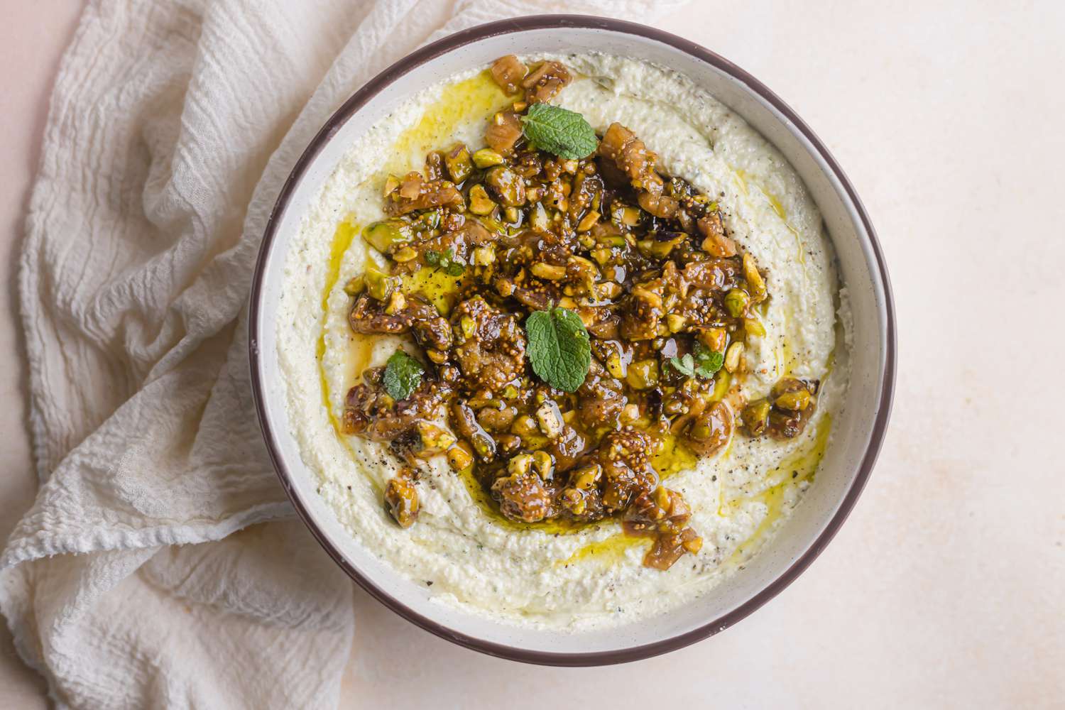 Whipped feta with figs, nuts, and honey in a bowl.