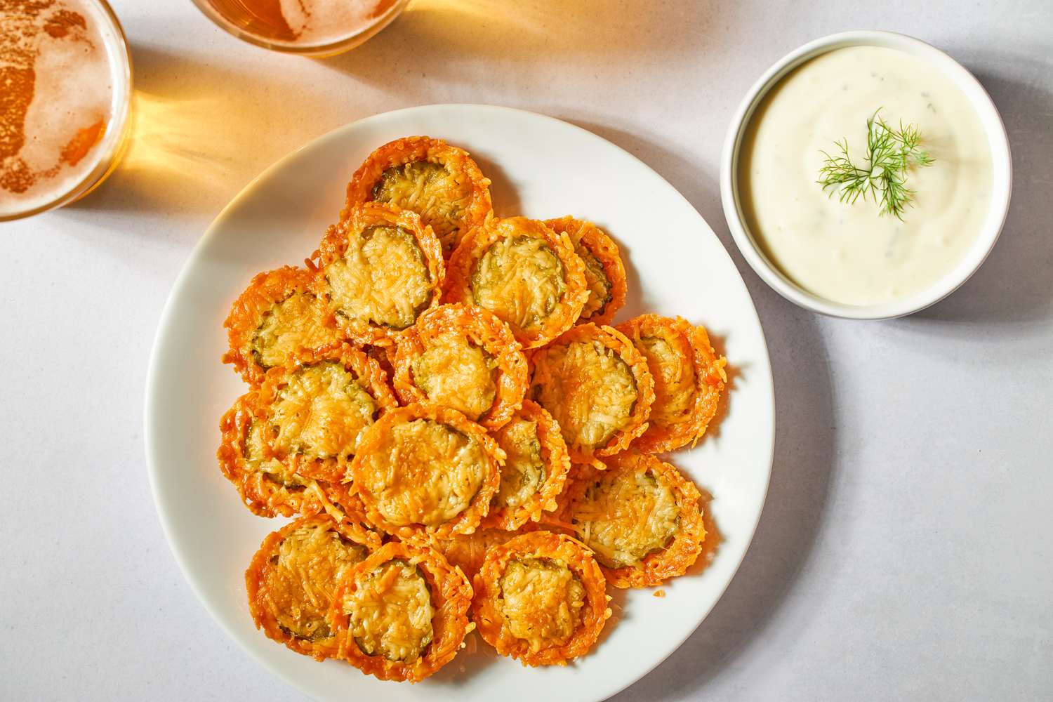 A plate of baked fried pickles with a side of dipping sauce