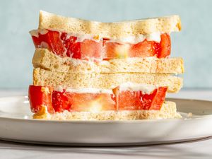 A tomato sandwich stacked, served on a plate