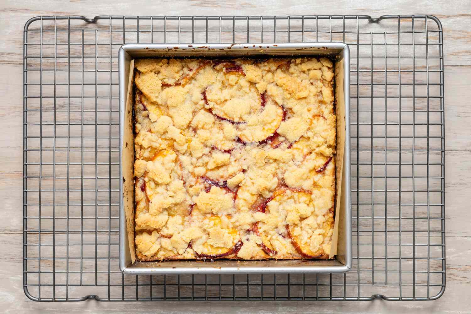 A pan of peach pie bars fresh out of the oven on a cooling rack