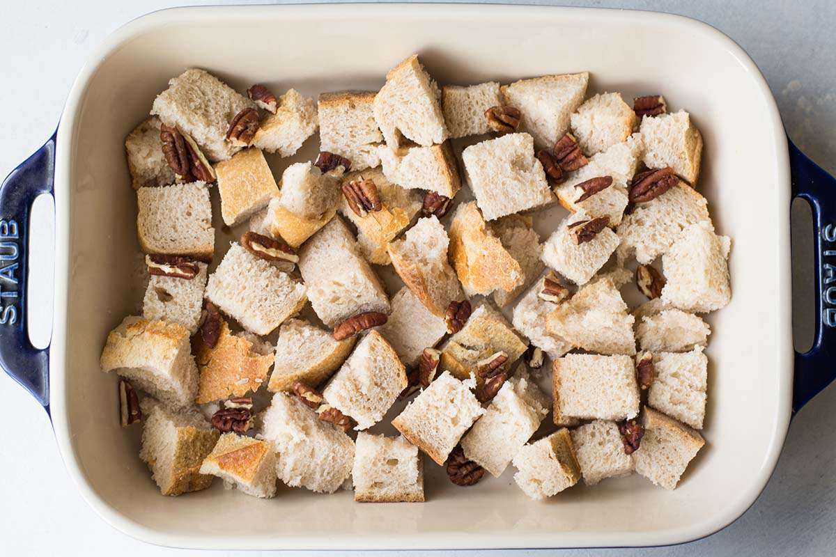 Bread cubes and chopped pecans in a casserole dish