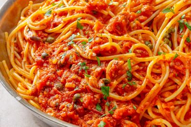 A pasta dish with sardine and tomato sauce garnished with herbs