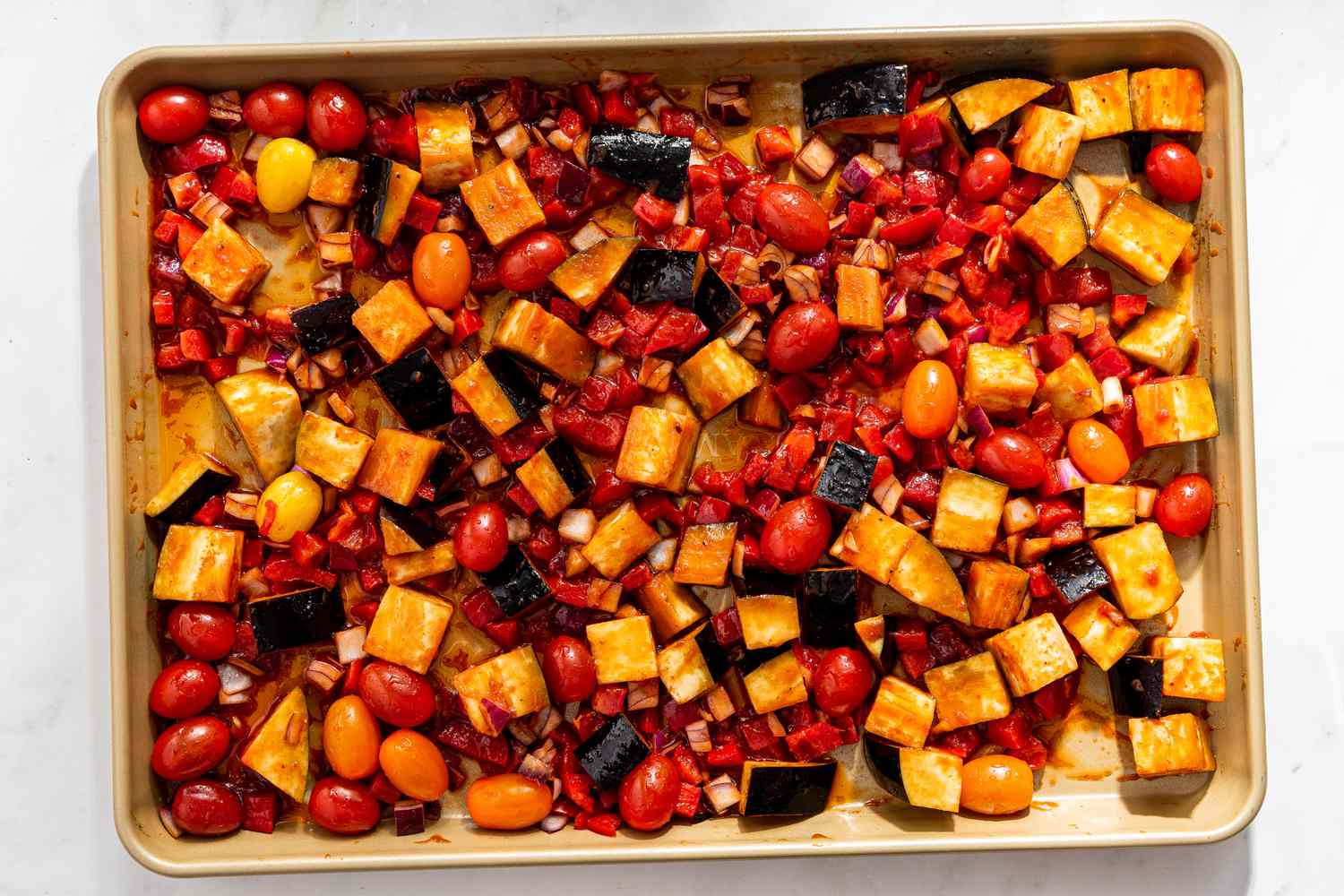 marinade mixed into the vegetables on the sheet pan for caponata pasta recipe 