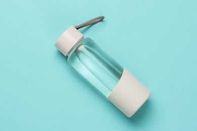 Bottle of water for sports and outdoor activities on blue background. Top view