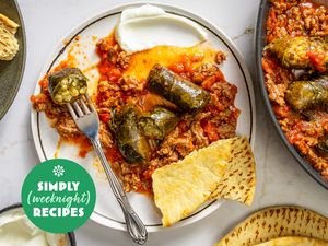 A plate of stuffed grape leaves with a side of flatbread and yogurt dip part of a Simply Weeknight Recipes presentation