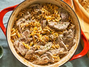 A Dutch oven full of beef stroganoff over corkscrew pasta