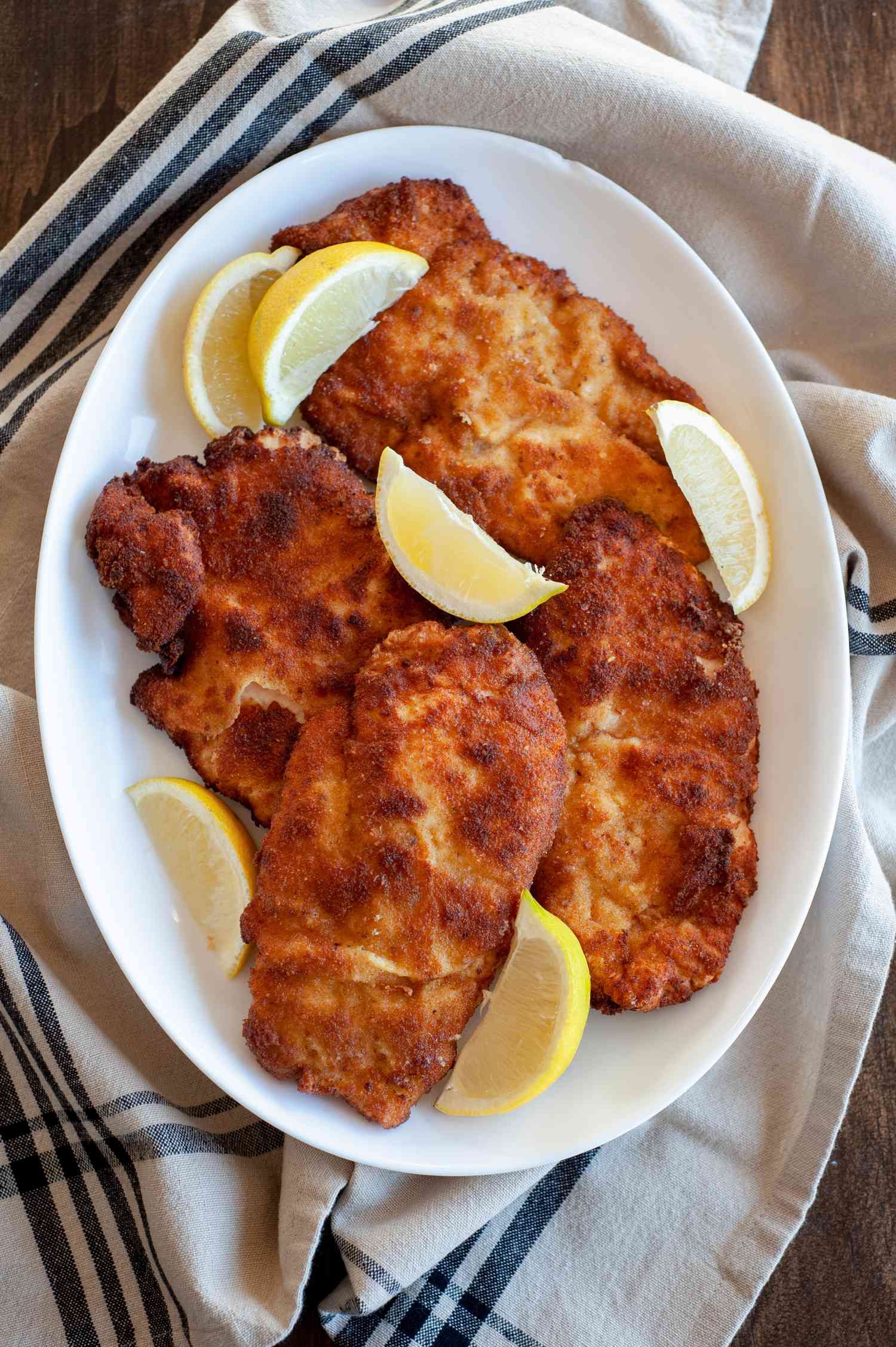 chicken schnitzel on platter with lemons
