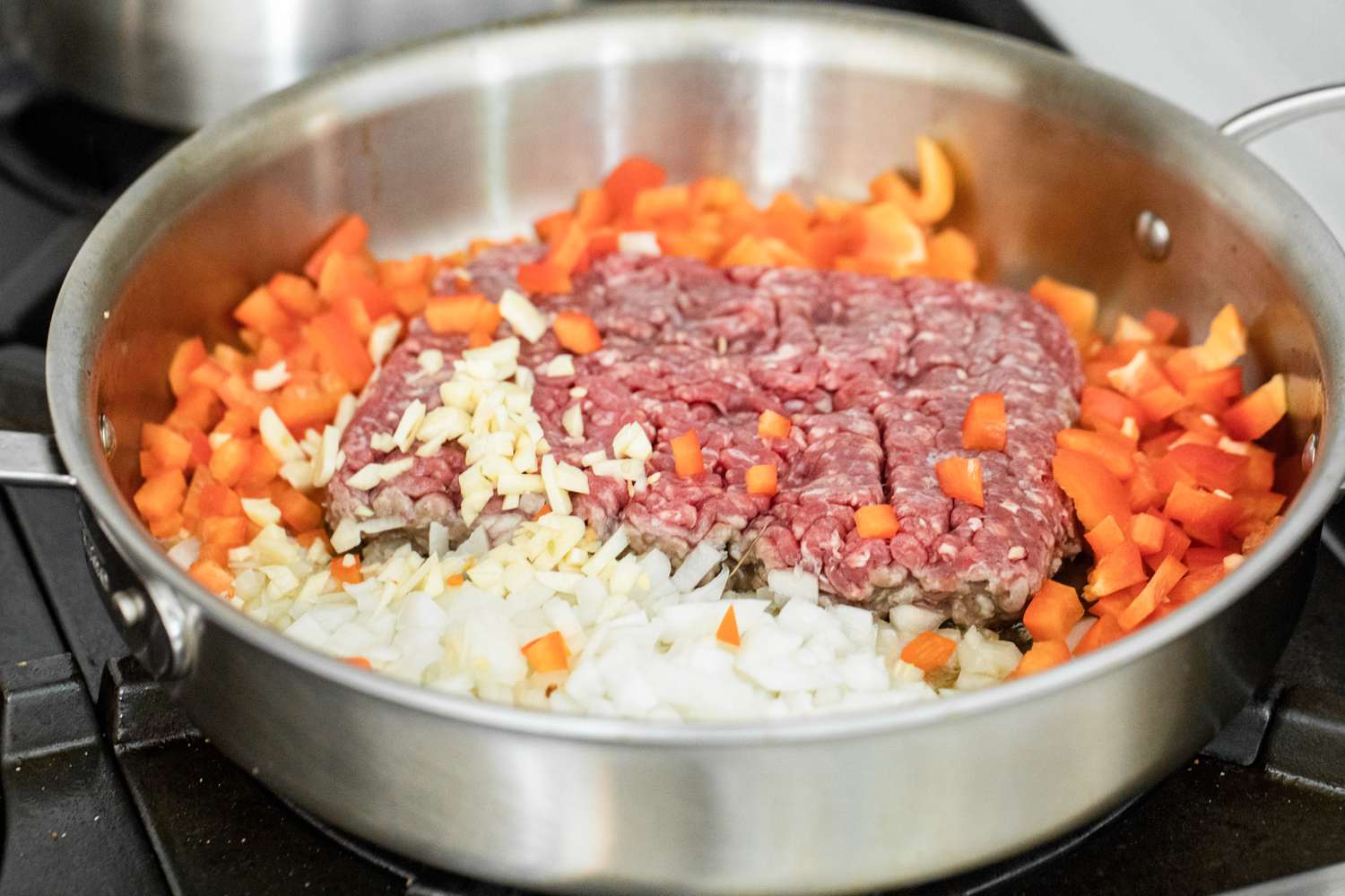 Ground Beef, Red Bell Peppers, and Onions in a Pot on a Stove for Loaded Sheet Pan Quesadillas Recipe