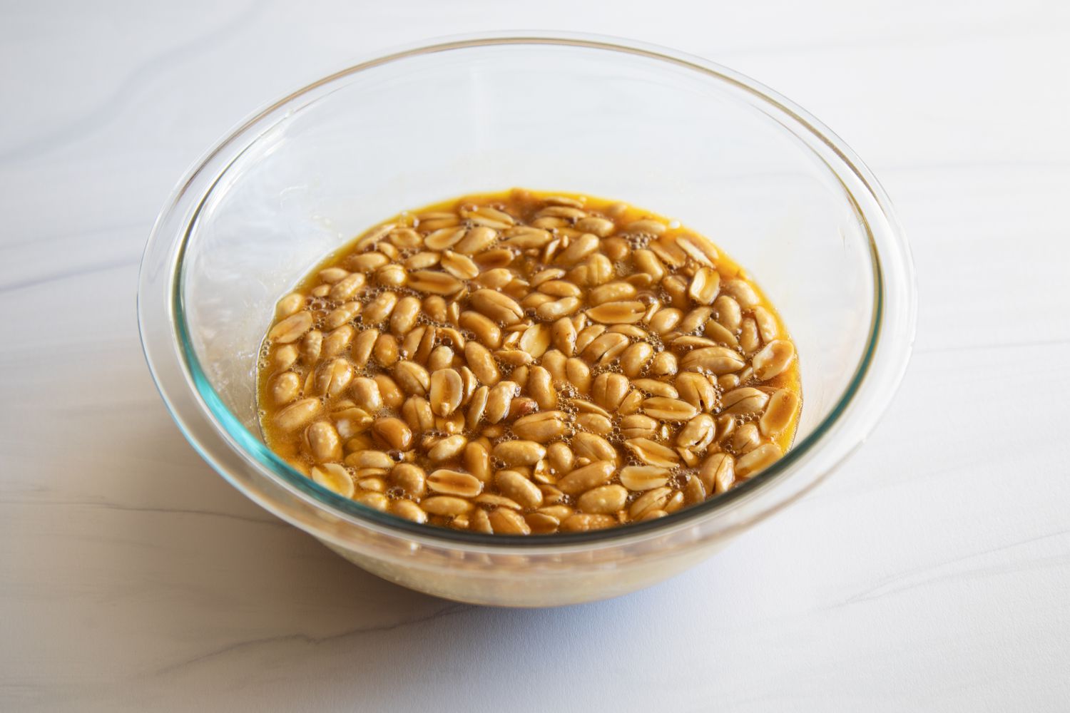 Peanuts soaking in a glass dish to make a Southern Peanut Pie.