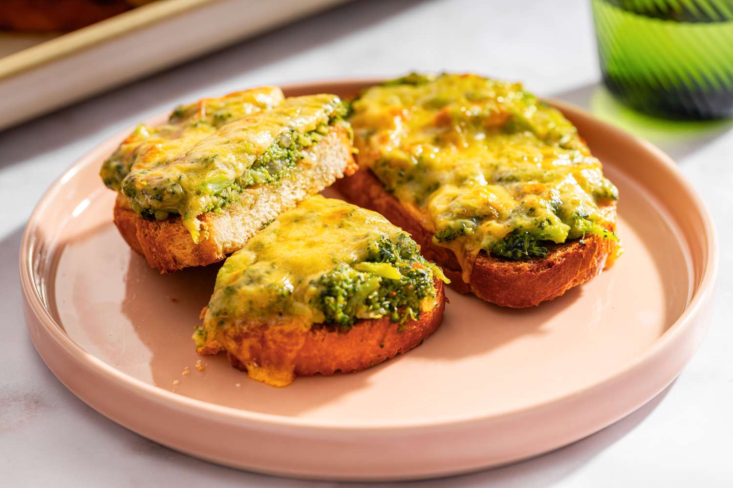 Broccoli cheddar toasts arranged on a ceramic plate