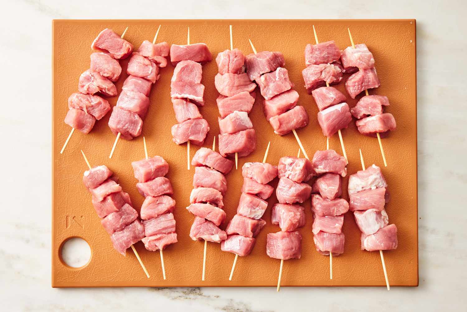 chicken pieces on skewers on a cutting board for City Chicken recipe