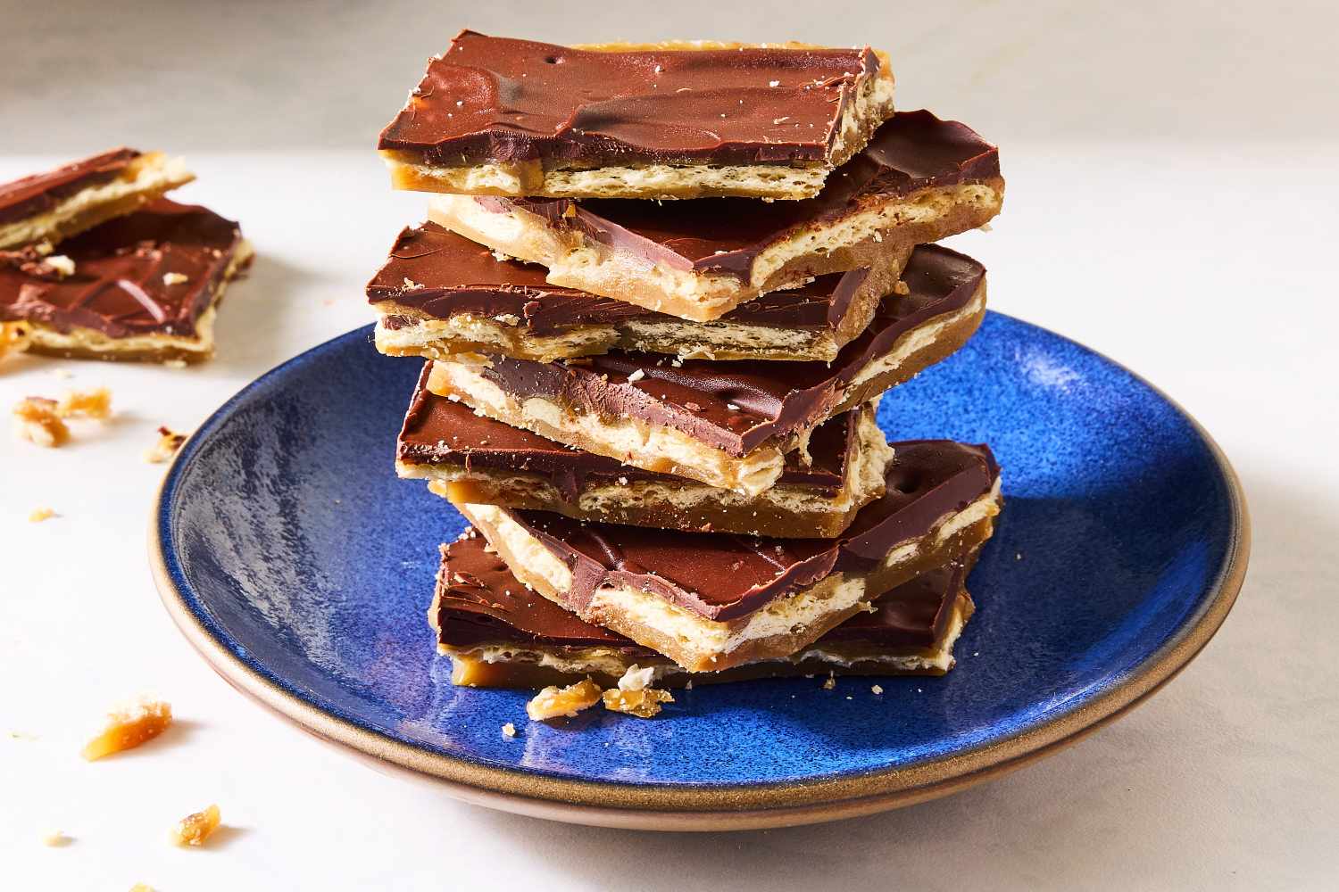 A stack of chocolatecovered cracker candy pieces on a blue plate