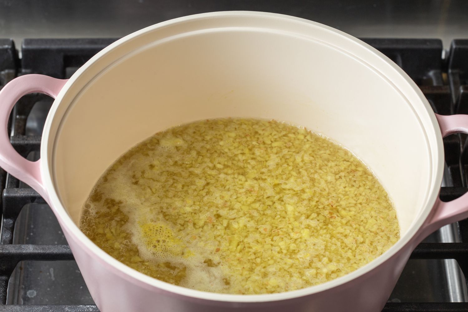 A dutch oven on the stovetop making a ginger beer recipe.