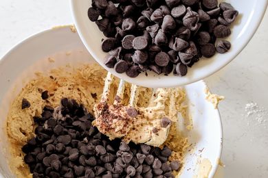 Mixing chocolate chips into a bowl of cookie dough