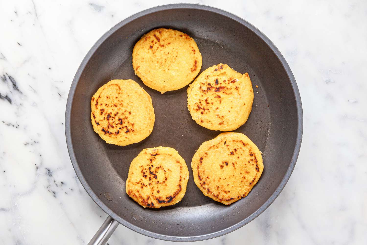 Cook arepas in a skillet.