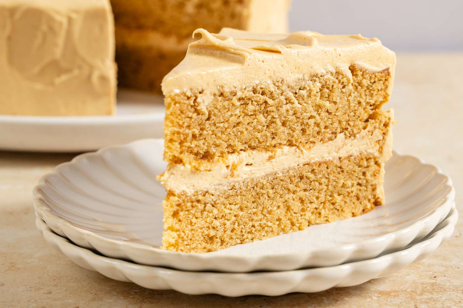 A slice of layered peanut butter cake on a stack of plates
