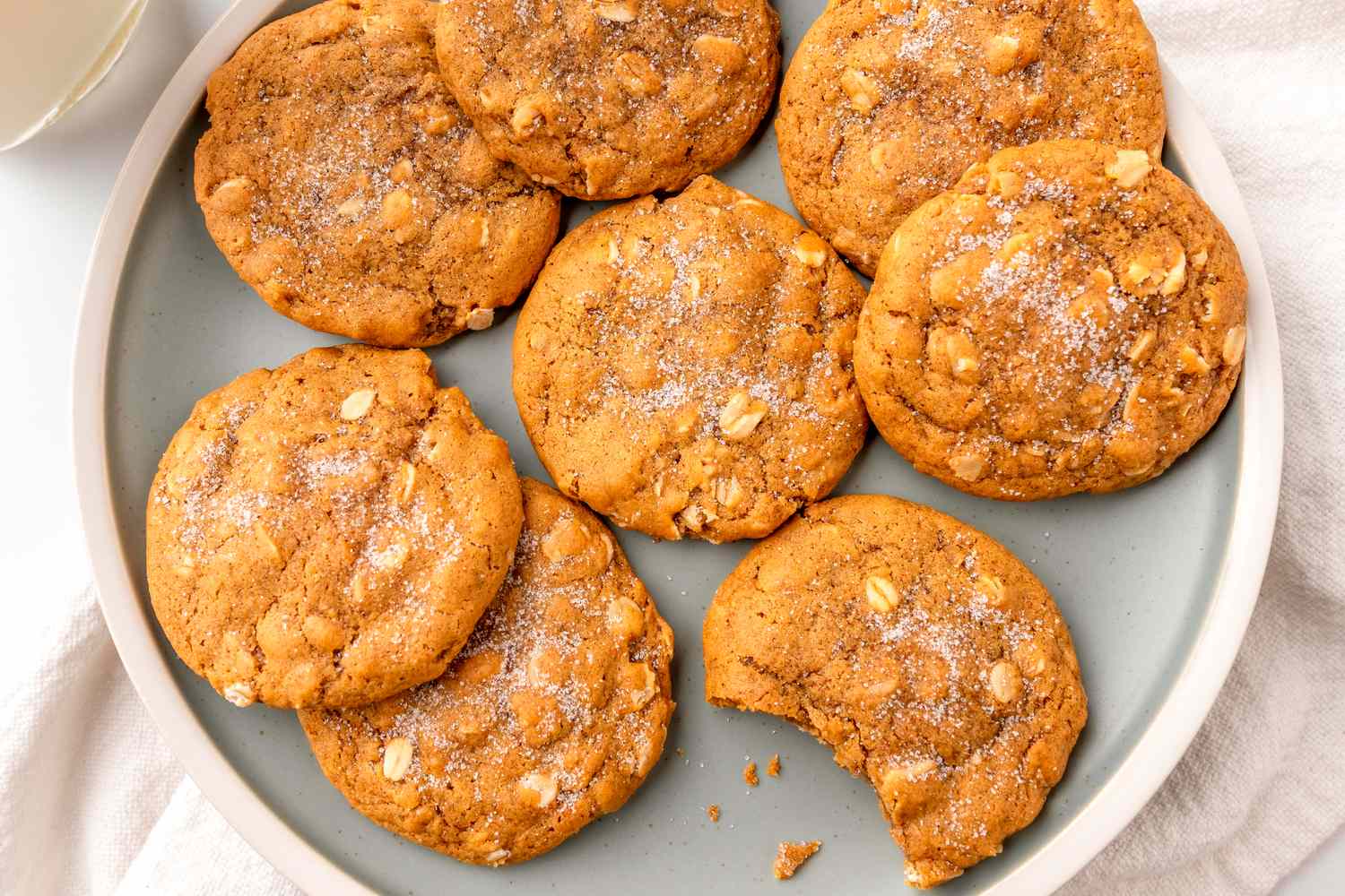 Plate of chewy oatmeal molasses cookies with one cookie partially eaten