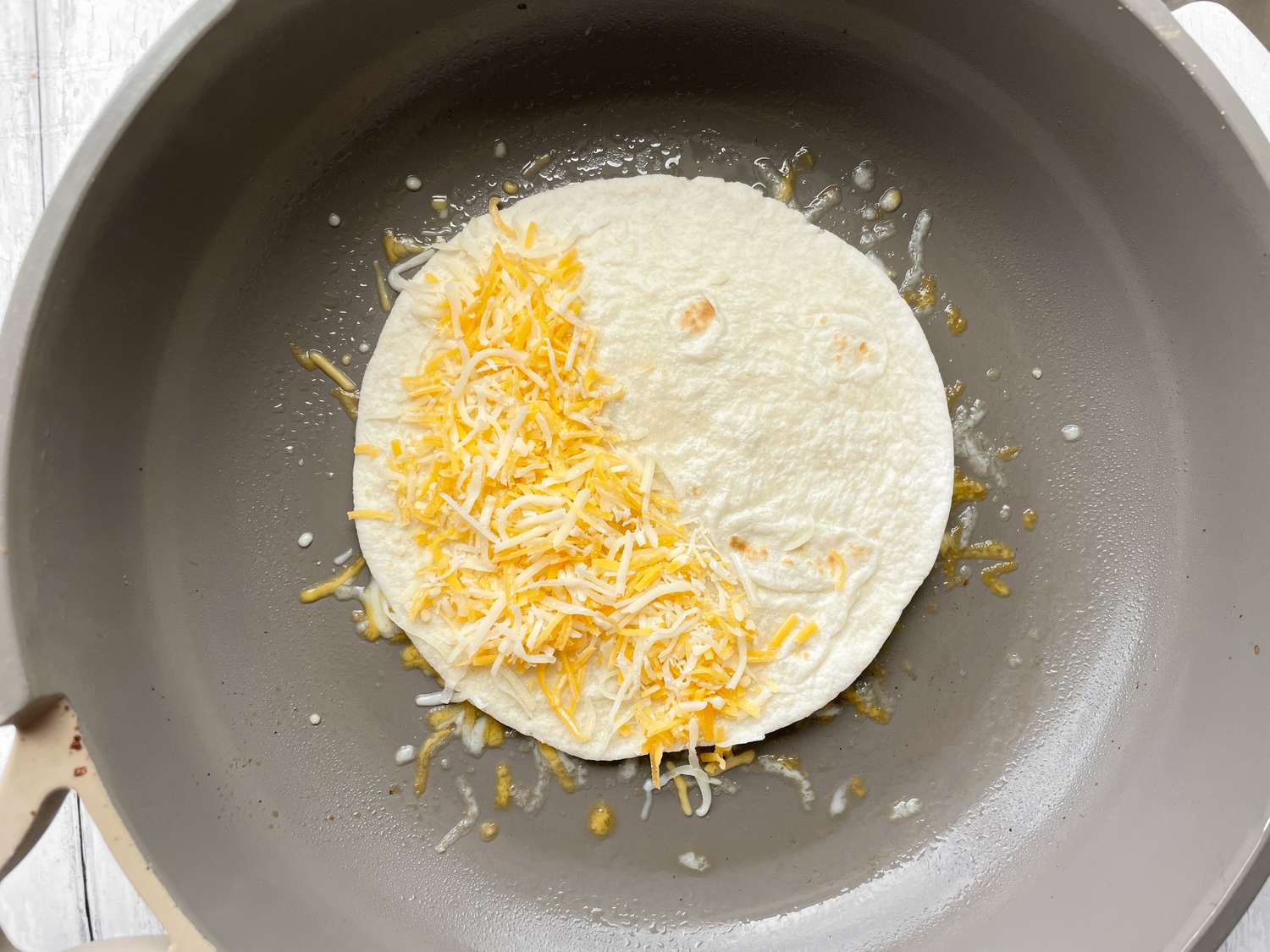 Cheese Added to Tortilla on Skillet for Burnt Cheese Taco