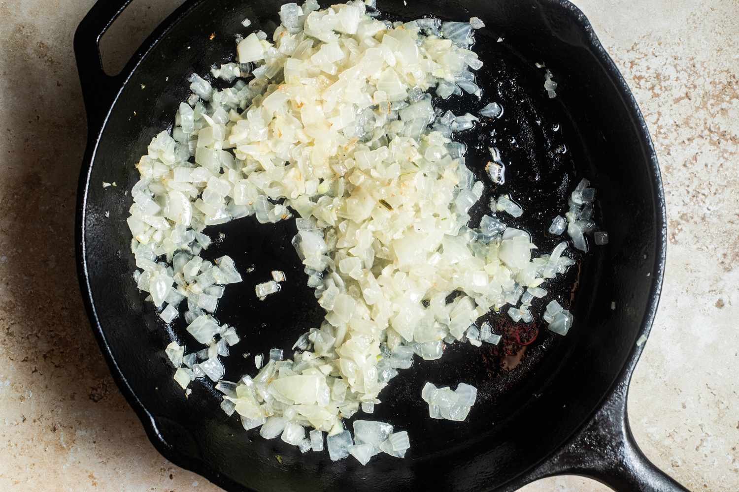 Sauteed onions in a cast iron skillet for walking taco casserole