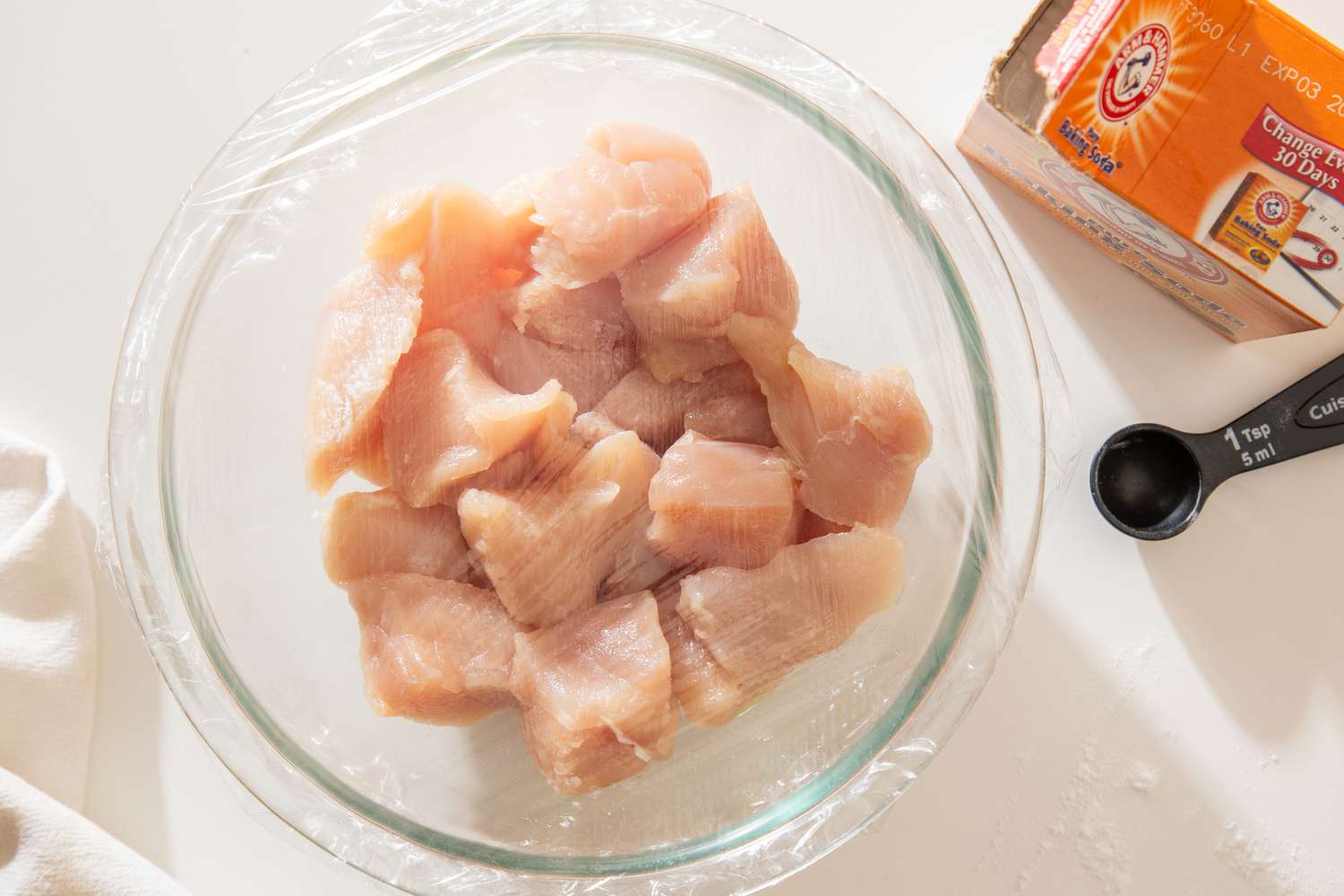 Plastic wrap over a bowl of velveted chicken