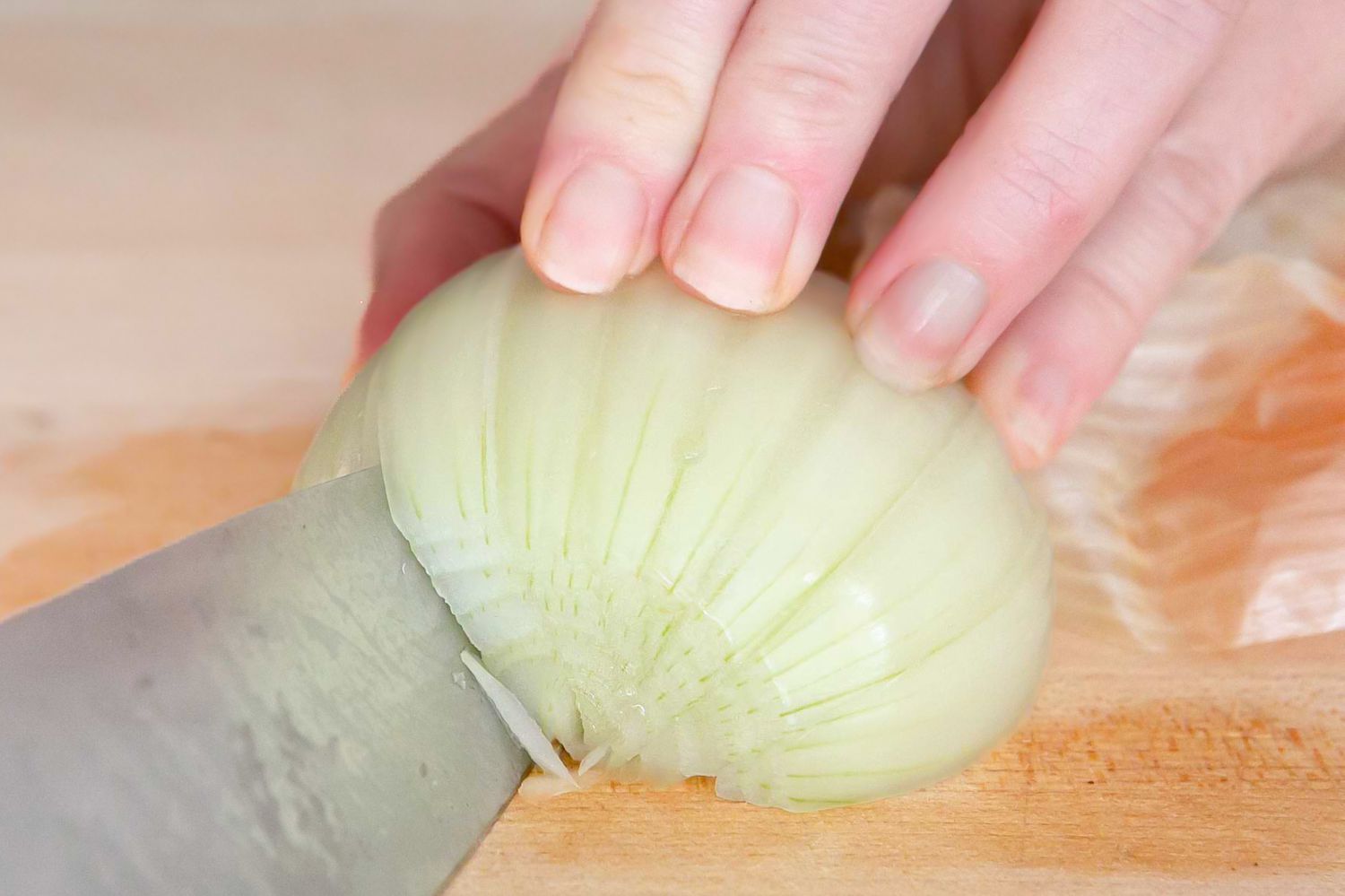 Knife Continuing To Cut the Onion at an Angle for How To Chop an Onion