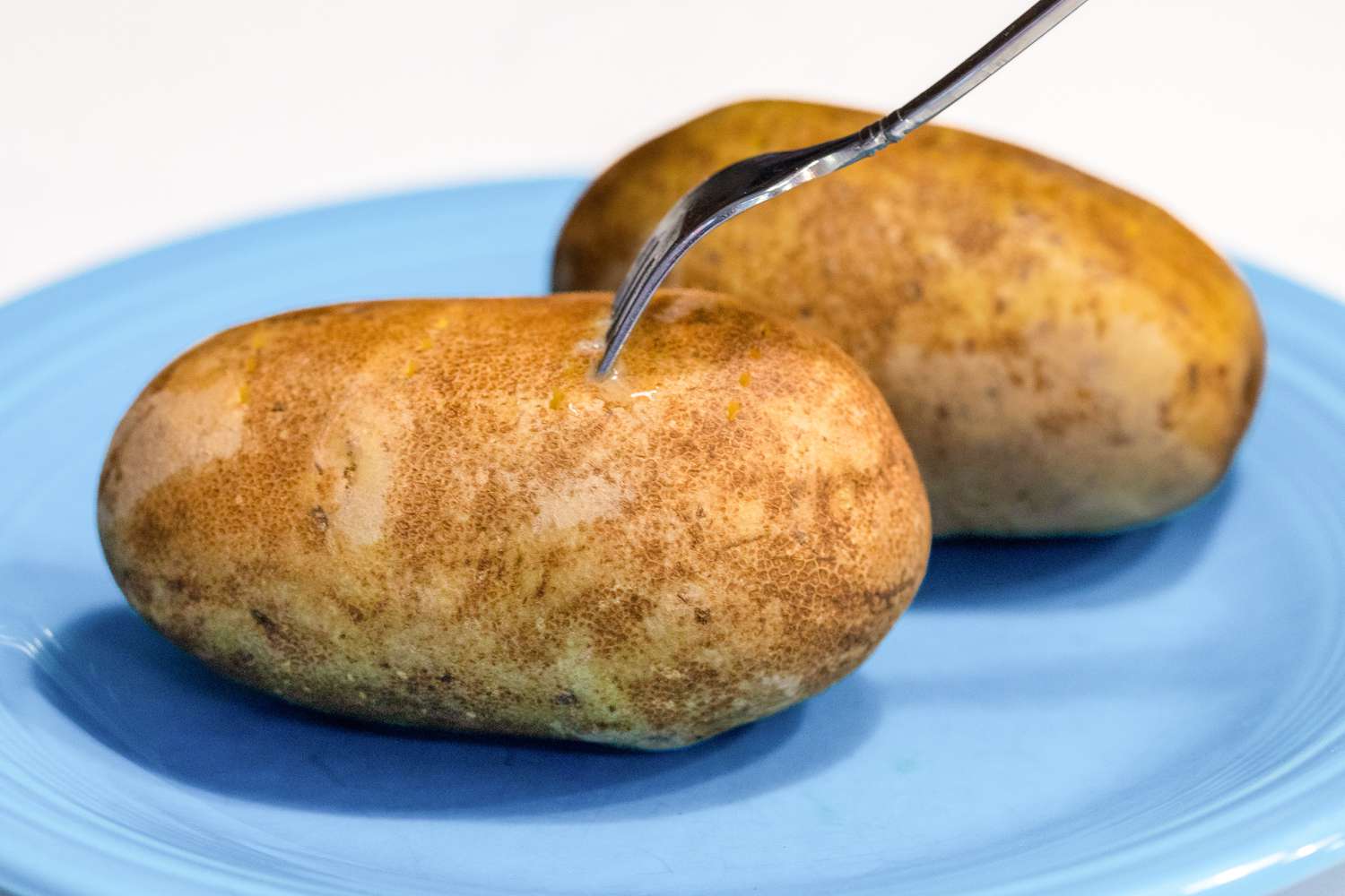 Russet Potatoes Poked with a Fork Prior to Cooking in the Microwave for Baked Potatoes Recipe