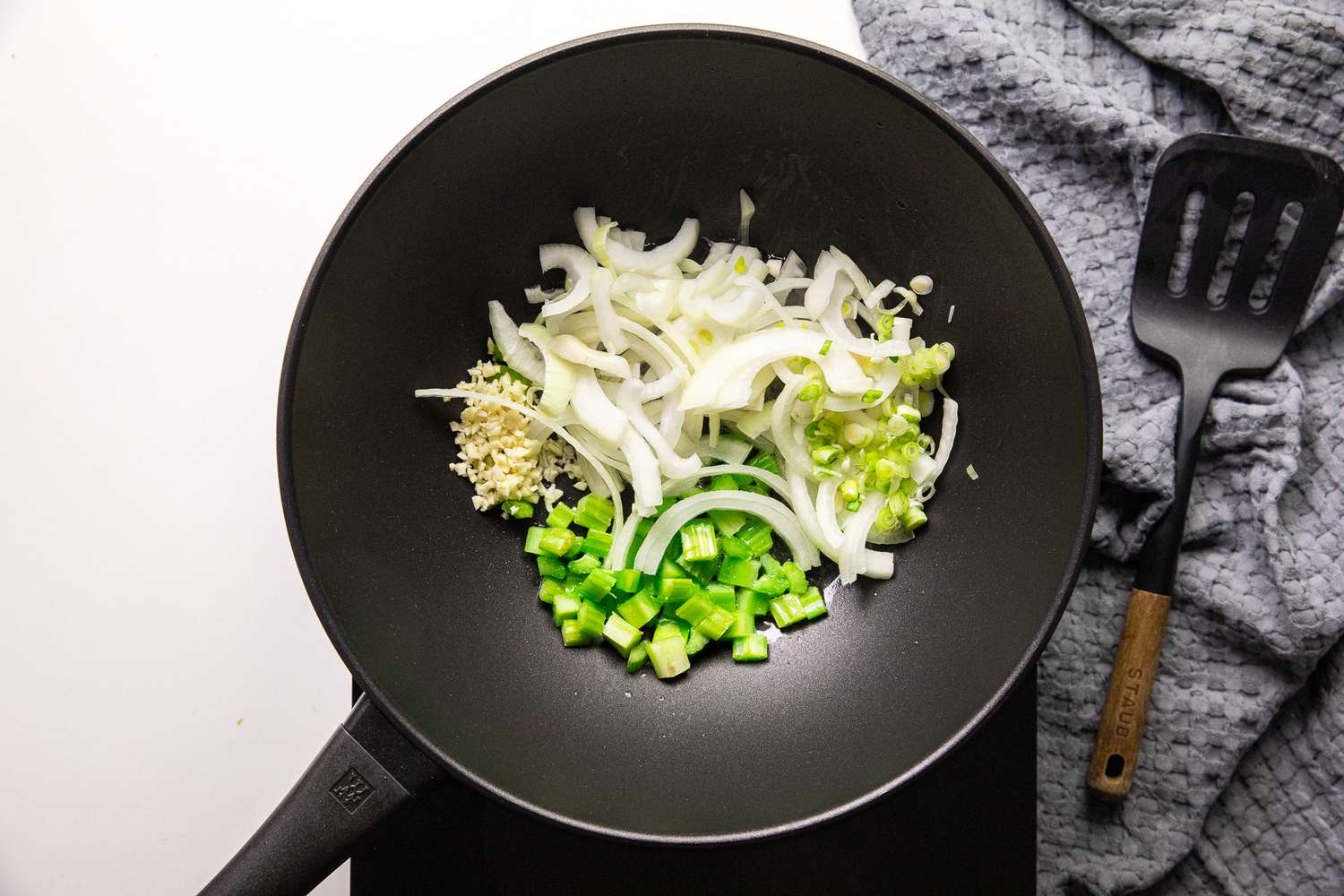 Onions, Green Onions, Celery, and Garlic Added to a Work for Pancit Bihon (Filipino Rice Noodles)