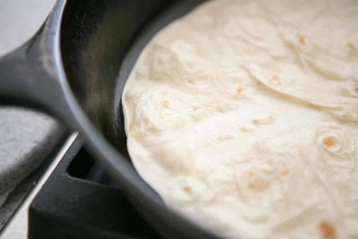 heat flour tortilla in cast iron pan