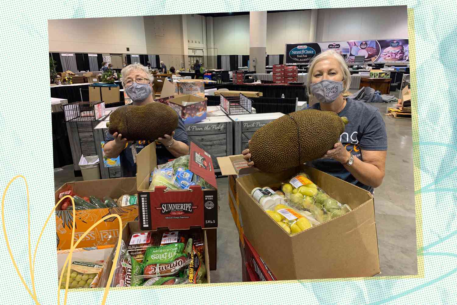 Two people holding large fruits in a warehouse