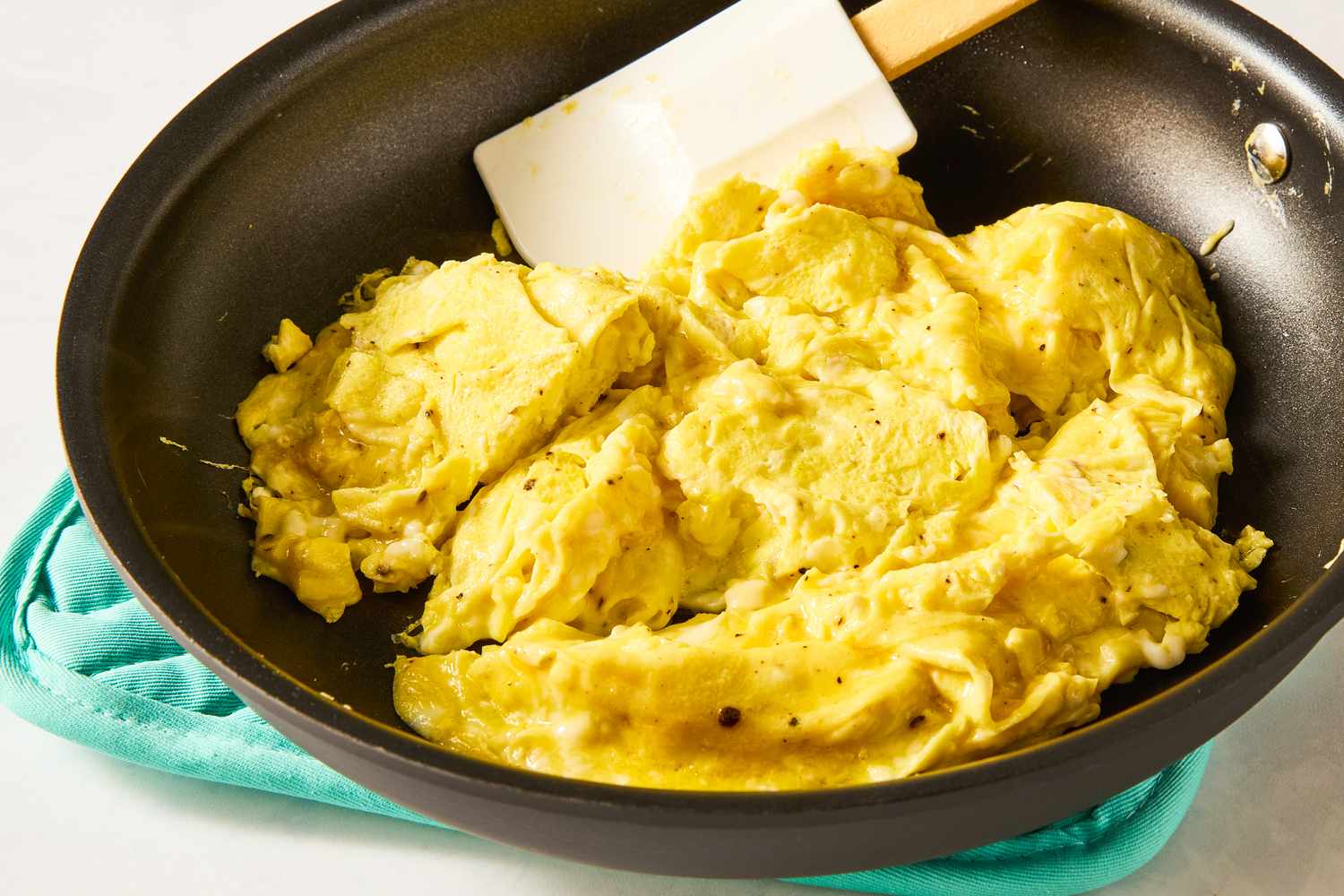 Scrambled eggs cooking in a skillet with a spatula