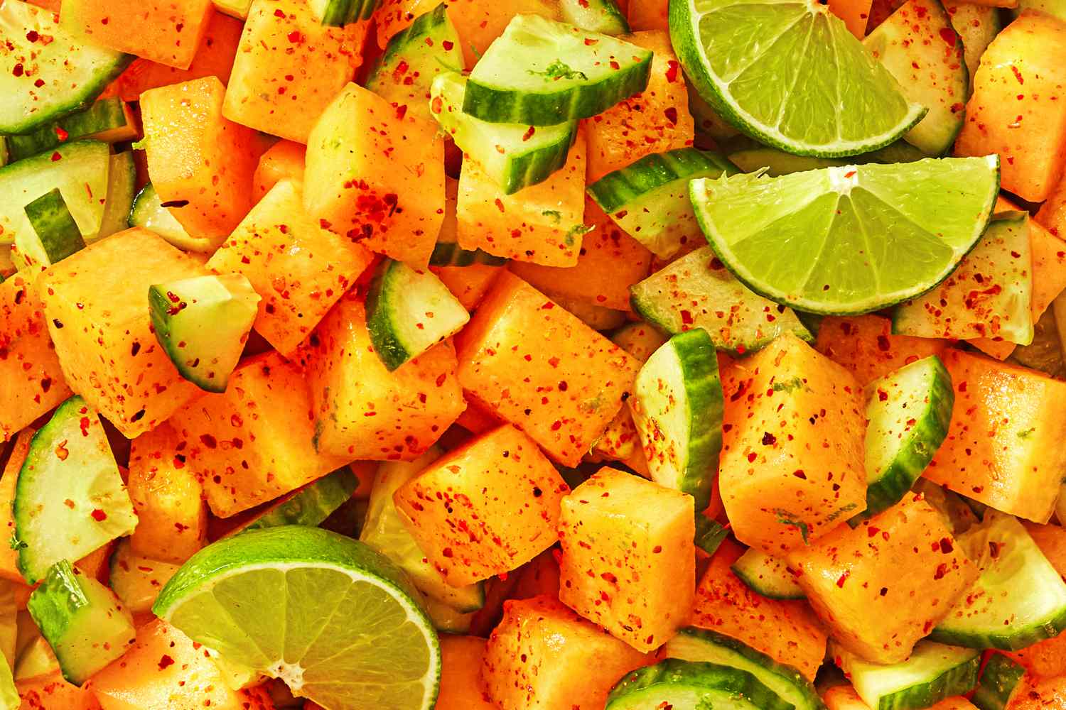 Cubed cantaloupe cucumber slices lime wedges and chili seasoning