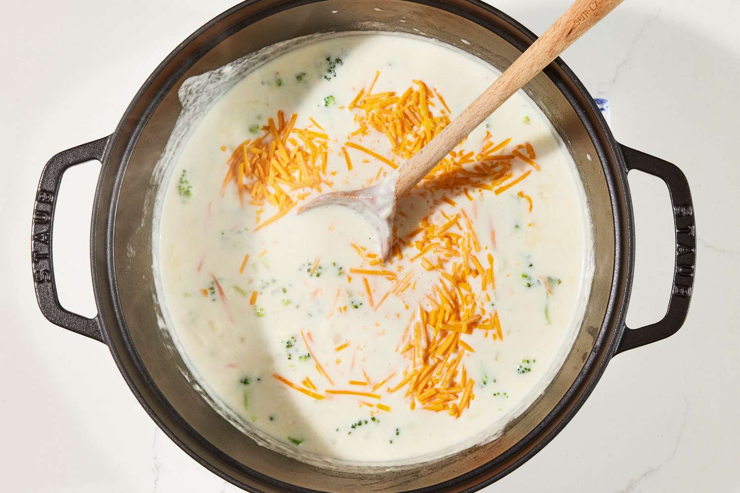 Shredded cheddar added to pot of copycat Panera broccoli cheddar soup