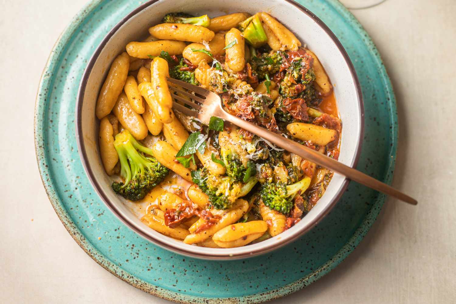 Bowl of Homemade Cavatelli, Broccoli, and Pasta Sauce With a Fork, All on a Plate