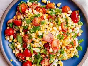 A plate of corn and tomato salad with herbs