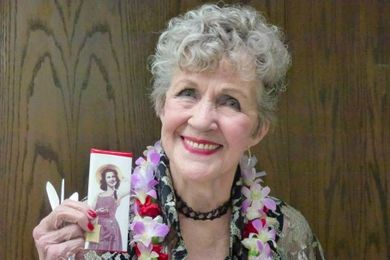 Elderly woman holding a product with a photograph of a woman on its packaging