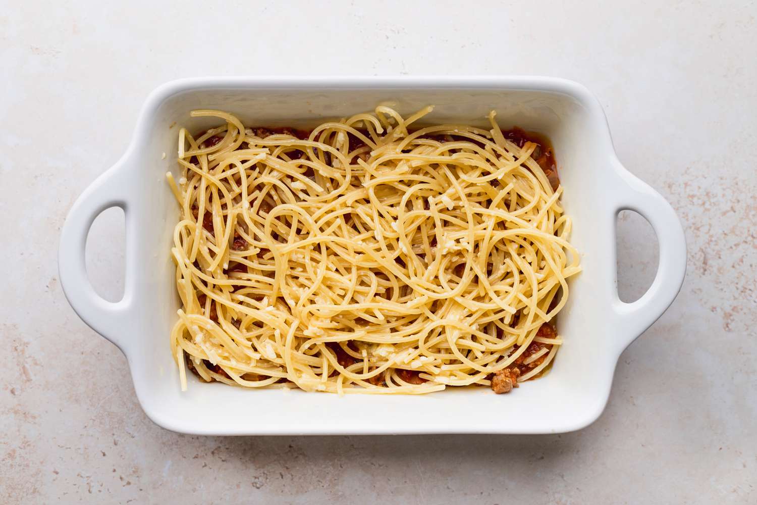 Baked Spaghetti layered in a dish before baking