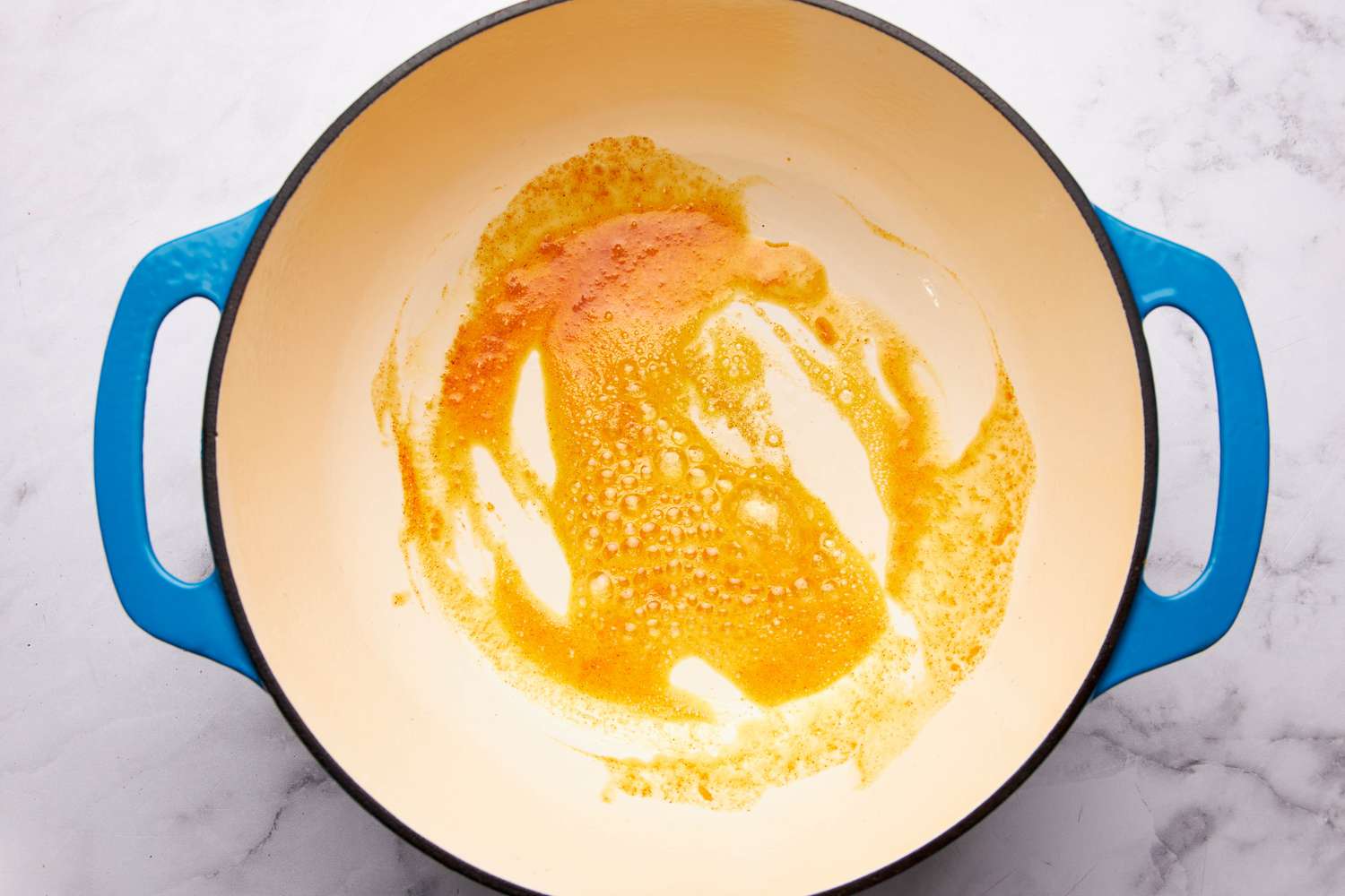 Melted butter and seasoning toasting in a dutch oven for one pot mac and cheese recipe