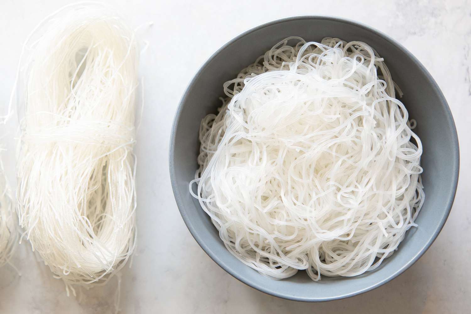 Dried Mung Bean Threads on the Left and Cooked Mung Bean Threads in a Bowl on the Right