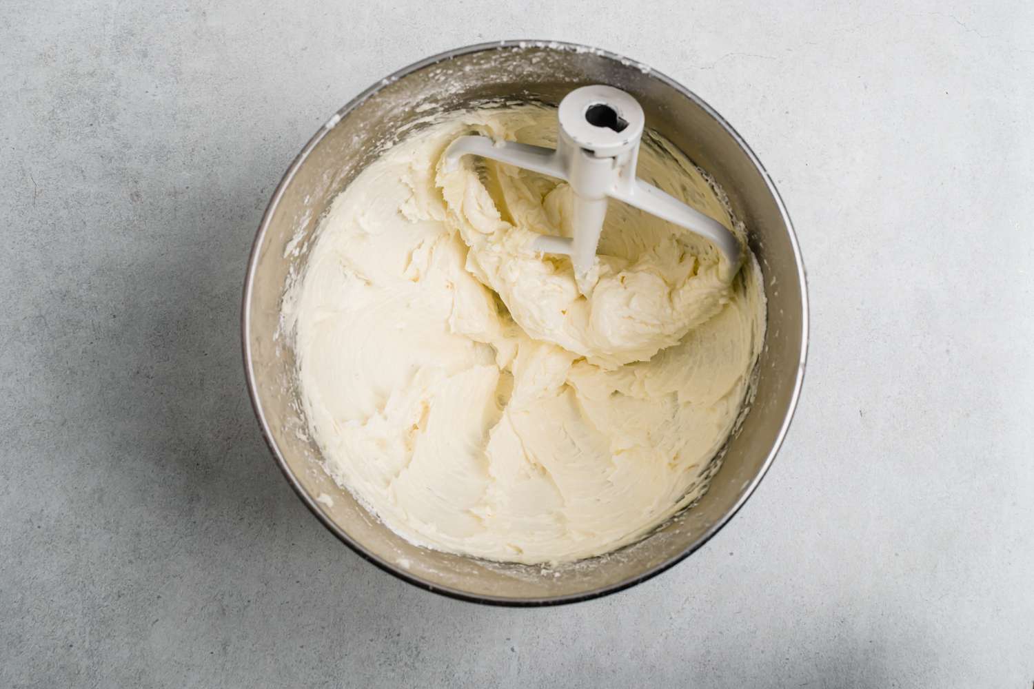 Butter and sugar creamed in the metal bowl of a stand mixer.