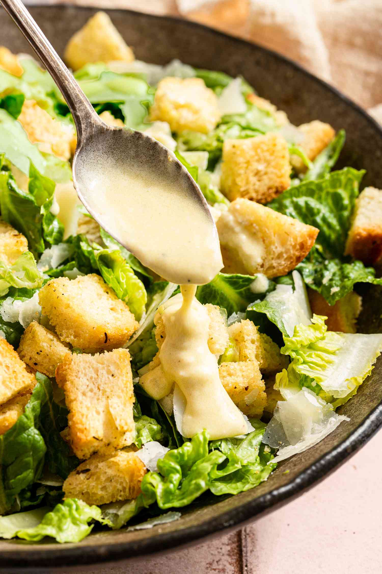 easy caesar dressing added to a caesar salad