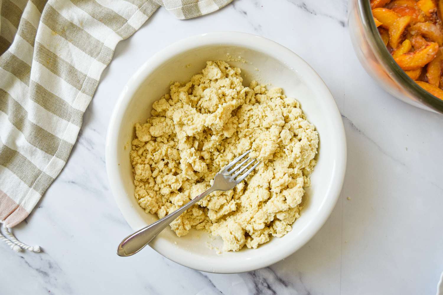 Bowl of Peach Cobbler Topping Mixed Together Using a Fork