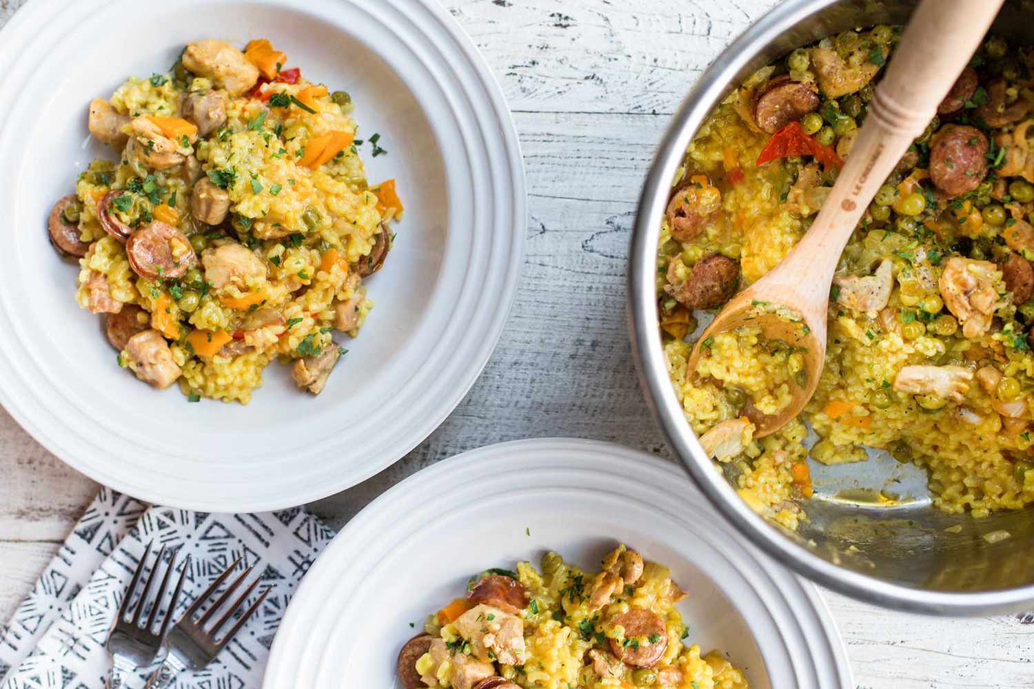 pressure cooker paella in the instant pot with two plates of paella alongsid
