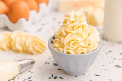 German buttercream piped in a prep bowl and a piping bag next to it.