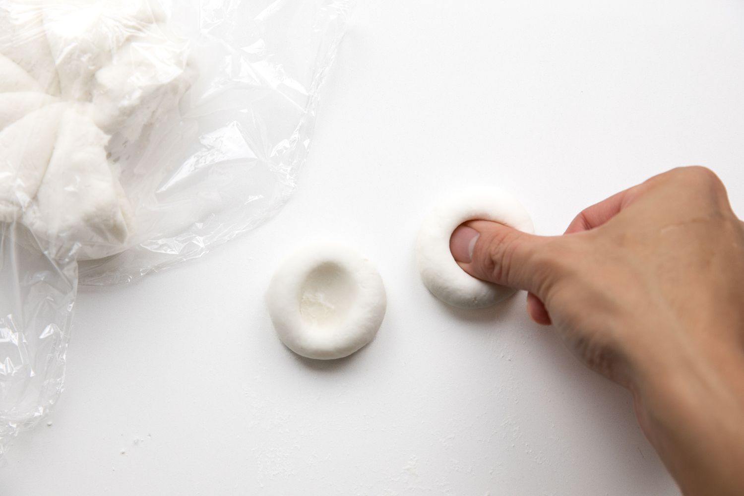Filling the Tangyuan (R to L): Thumb Used to Create Indents on Both Small Rolled Dough Balls and the Rest of the Divided Dough Ball under Plastic Wrap