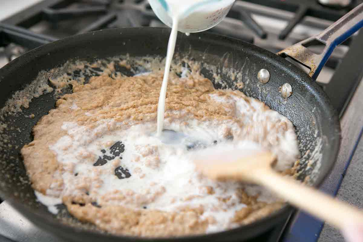 Stirring milk into gravy for country fried steak